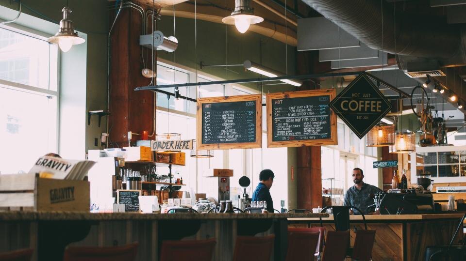 Café com balcão e clientes ao fundo
